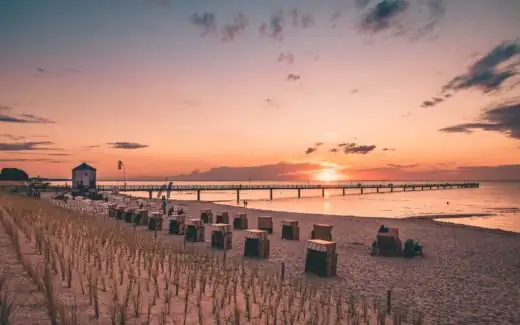 Seebrücke Lubmin mit Strandkörben davor zum Sonnenuntergang