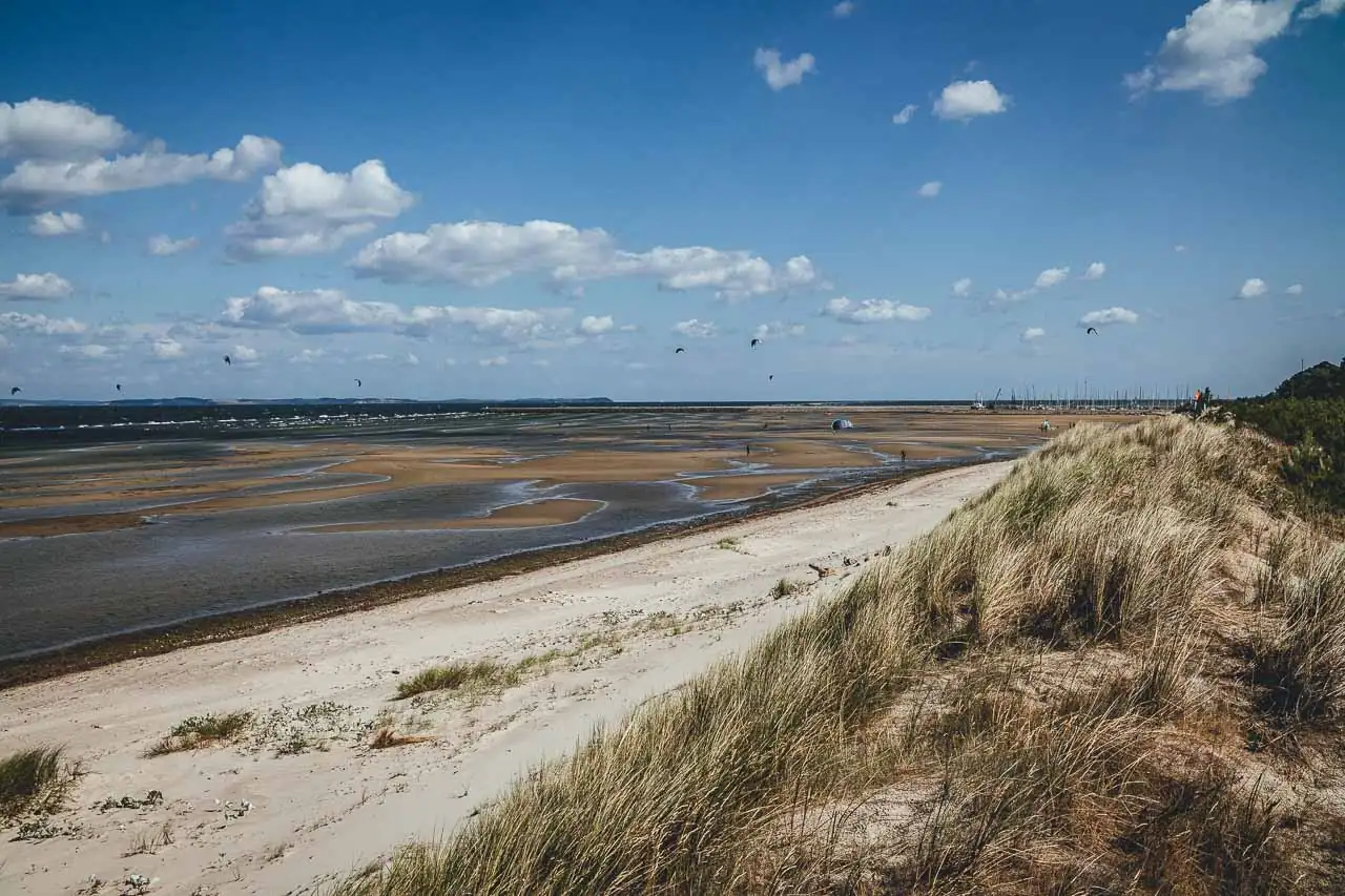 Blick auf den Strand bei ablandigen Wind mit vielen Kitesurfern