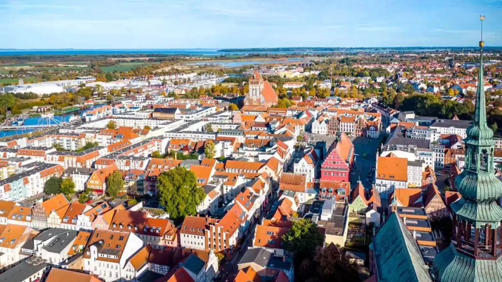 Luftaufnahme der Greifswalder Altstadt mit Marktplatz, Dom St. Nikolai und Hafen – zentrale Lage vieler Hotels in Greifswald